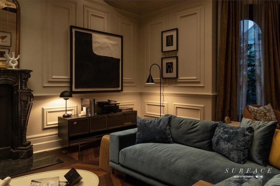 Elegant traditional living room with cream paneled walls, dark wood furniture, and warm ambient lighting