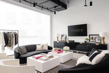 Modern workspace with black seating, white storage, neon accents, and neutral tones