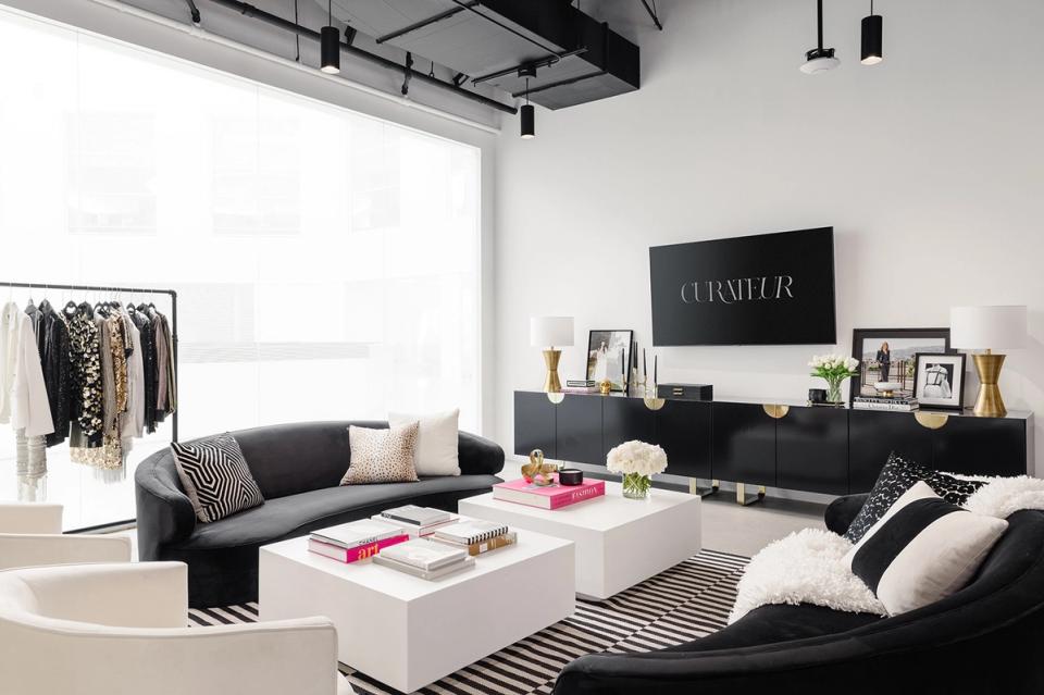 Modern workspace with black seating, white storage, neon accents, and neutral tones