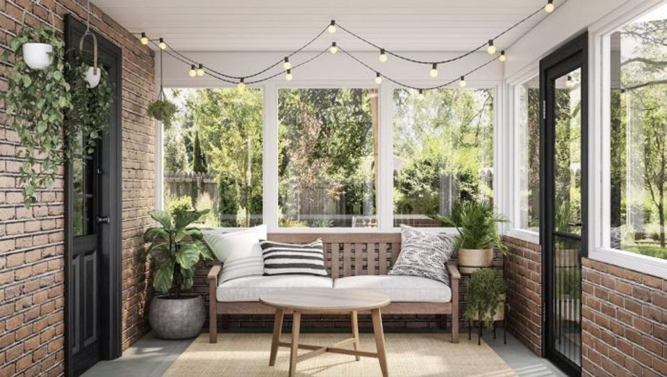 Bright sunroom with string lights, mid-century wood seating, green plants, and scandinavian-inspired minimalist comfort.