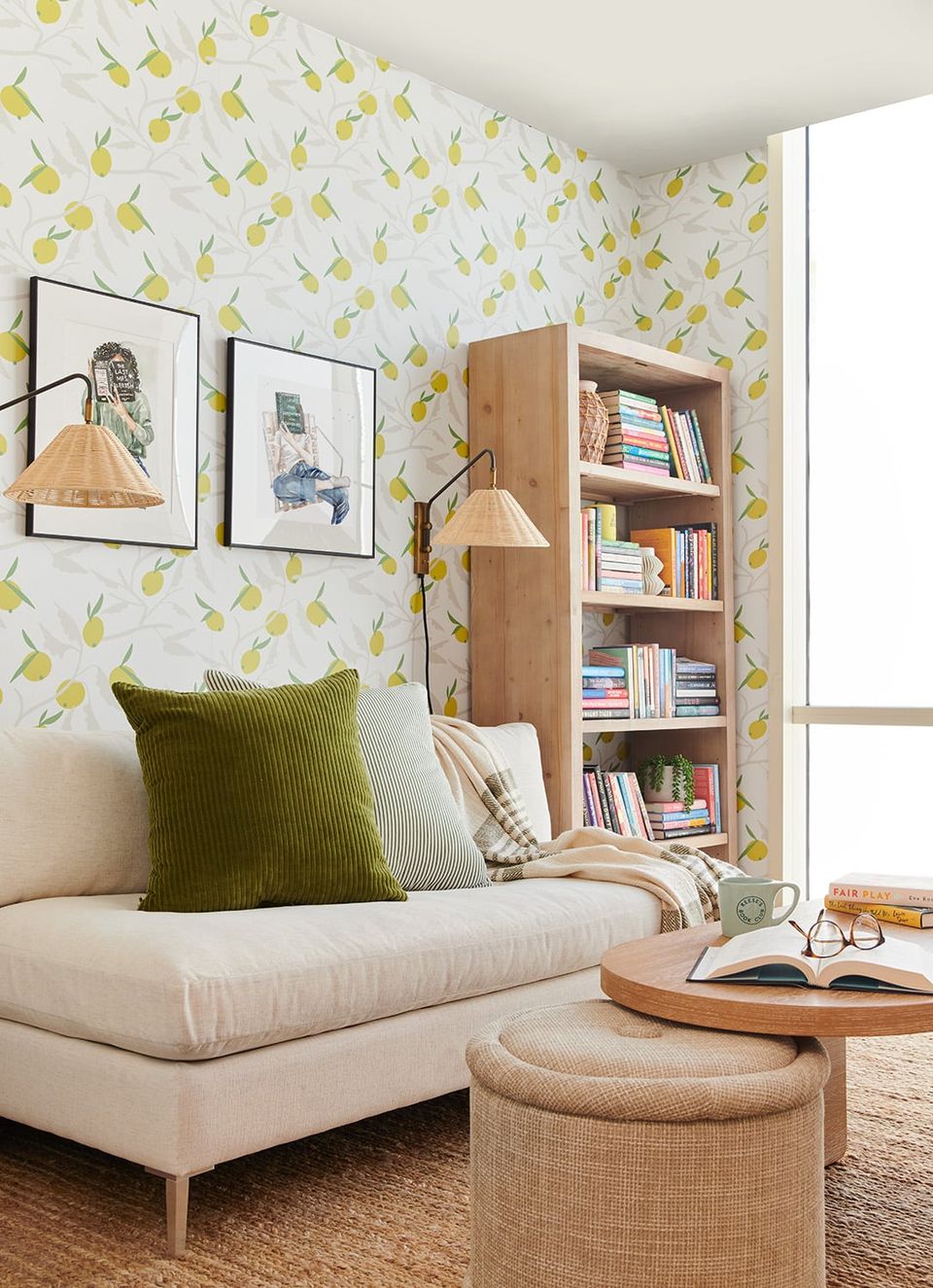 Bright reading nook with yellow geometric wallpaper, natural wood shelving, cream seating, and botanical artwork in a cheerful, contemporary style