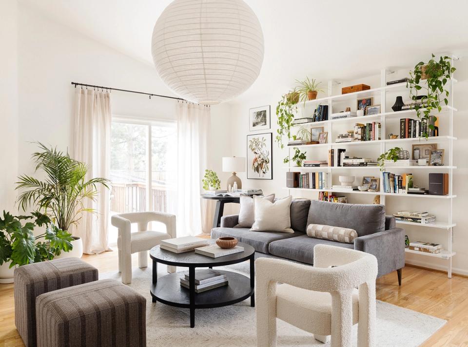 Botanical minimalist space with floor-to-ceiling shelving, potted plants, and neutral palette