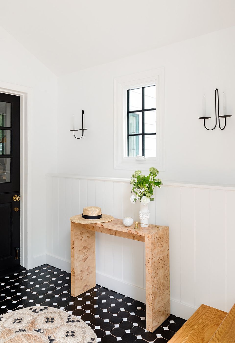 Minimalist entryway with white wainscoting moulding, natural cork console, and serene coastal-inspired calm