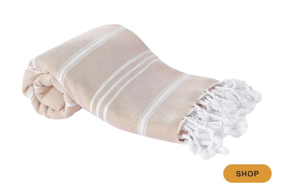 Neutral linen throw with cream stripes and fringe, relaxed coastal-inspired styling