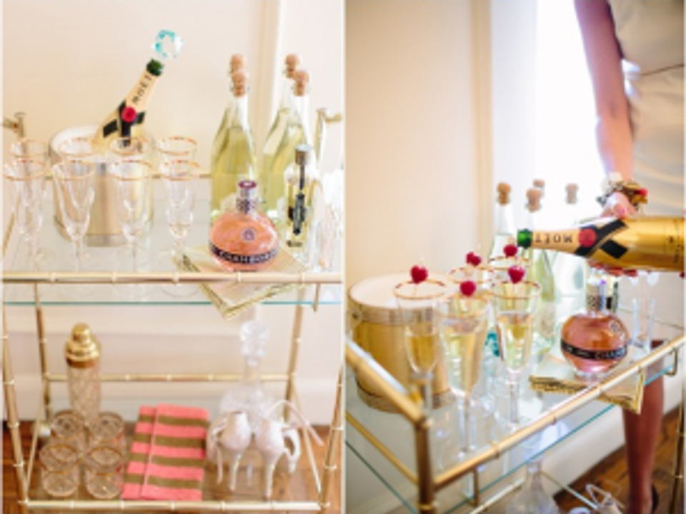 Glamorous gold bar cart styled with colorful spirits, fresh berries, and minimalist glassware arrangement