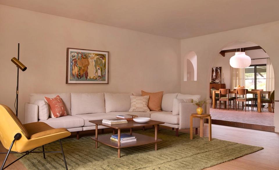 Warm mid-century modern living room blending vintage and contemporary styles with neutral tones, geometric accents, and mixed wood furniture.