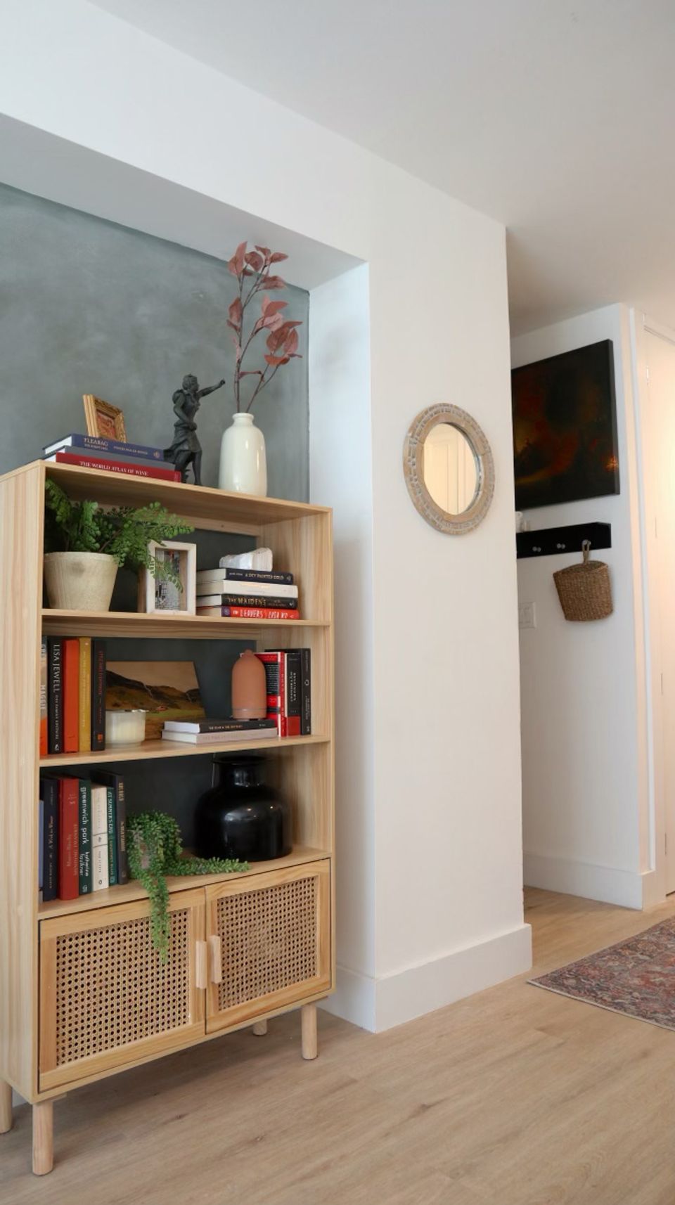 Scandinavian living room with two-tone limewash wall, rattan shelving, and warm neutral palette.