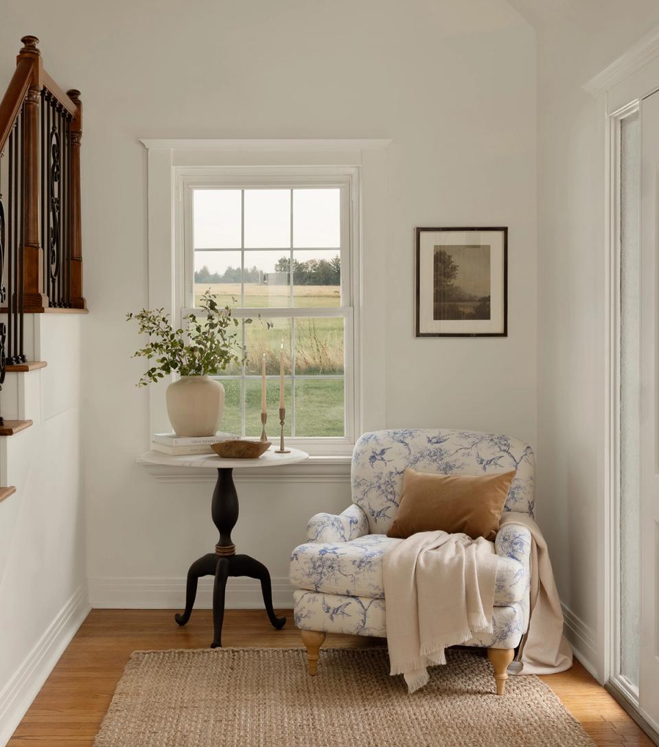 Serene farmhouse nook with floral upholstered chair, mustard accent pillow, and black side table in soft, neutral palette