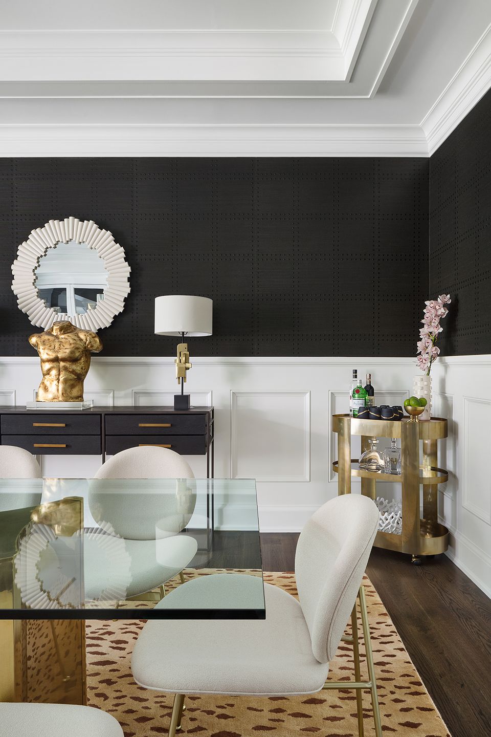 Sophisticated black and white dining room with gold metallic accents, shiplap paneling, and geometric patterned rug