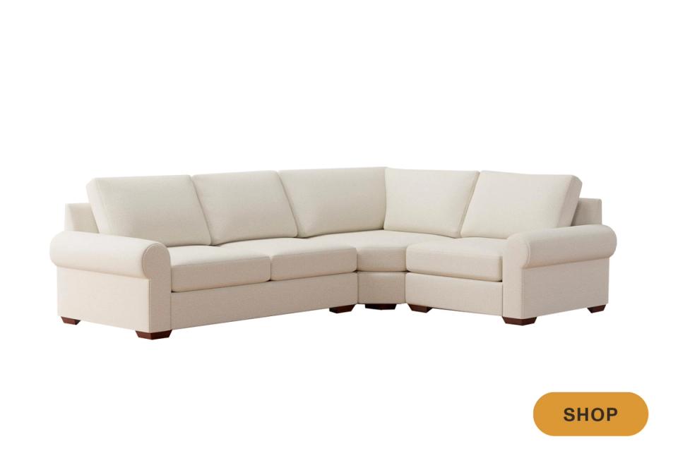 Transitional cream curved sectional with rolled arms and classic comfortable silhouette