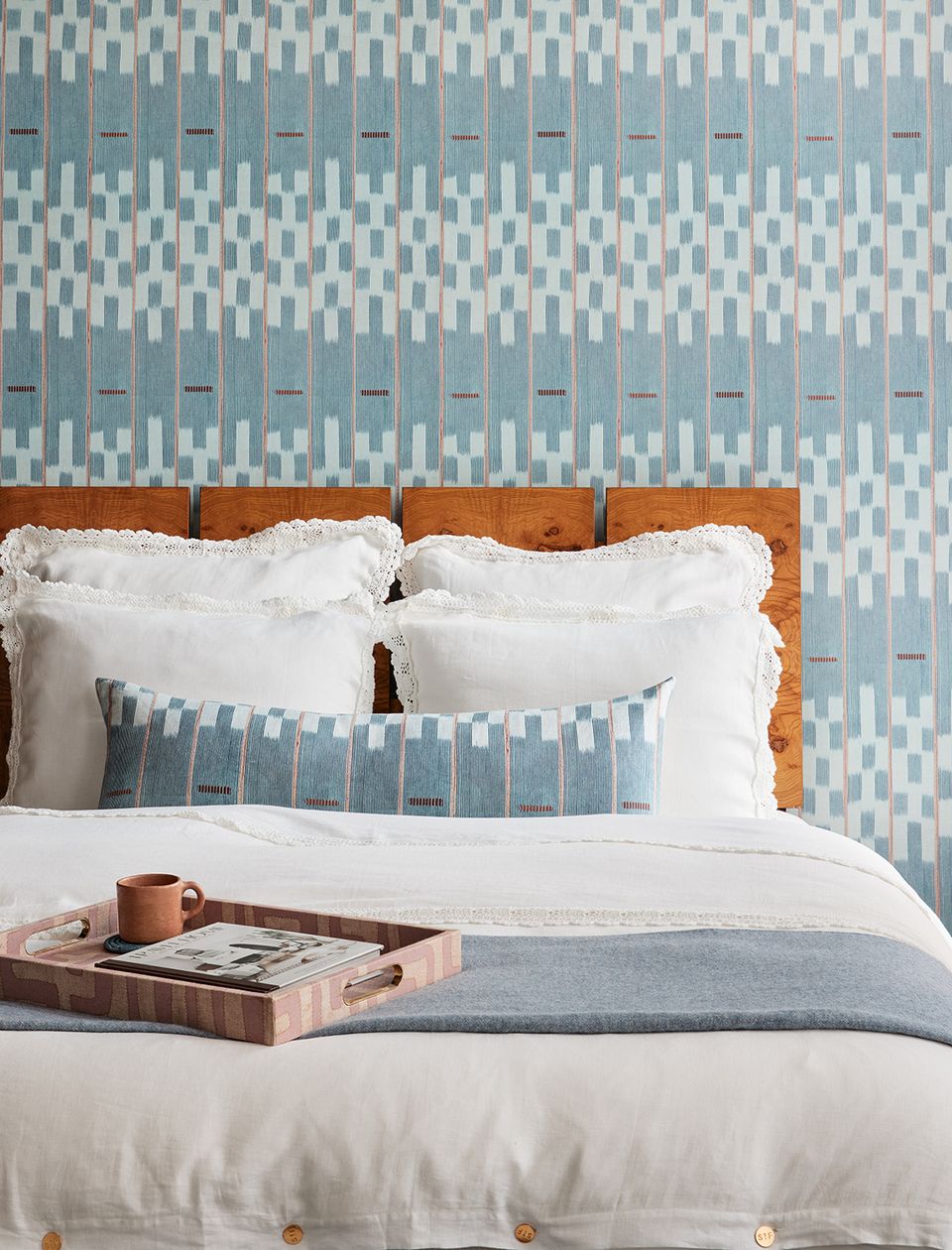 Serene bedroom with sage wallpaper, geometric pattern, white linens, wood bed frame