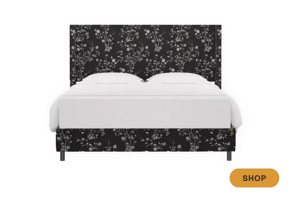 Modern bed frame with dark charcoal floral upholstered headboard and clean white bedding