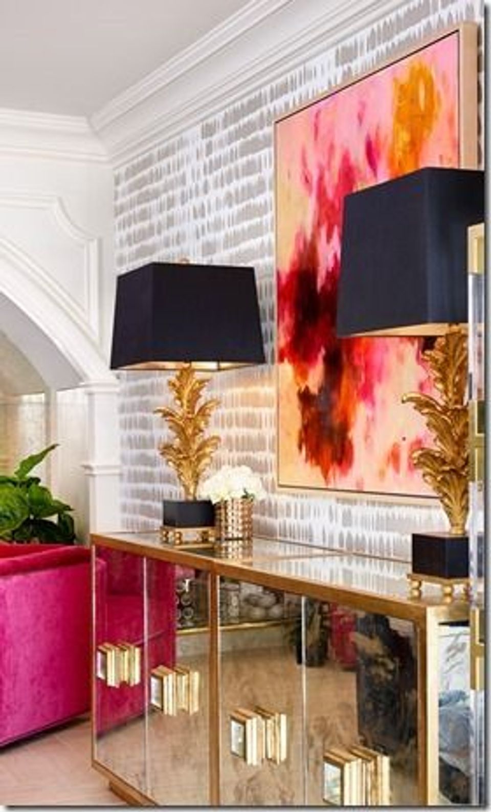 Luxe modern entryway with bold abstract art, black swing-arm lamps, brass accents, and jewel-tone storage pieces