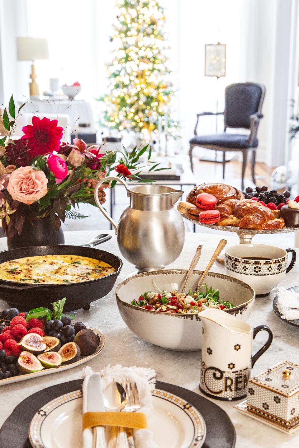 Vibrant colorful tablescape with pink florals, gold accents, and festive holiday serving pieces