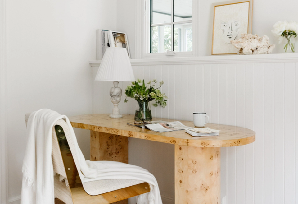 Warm minimalist workspace with natural wood desk and white accents