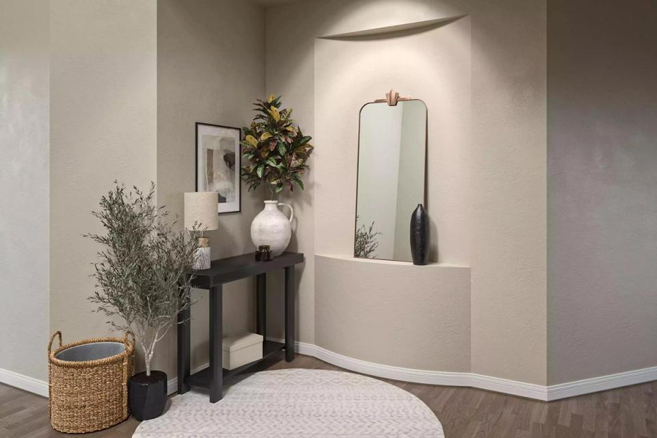 Modern entryway with taupe walls, dark console, minimalist aesthetic, brass accents