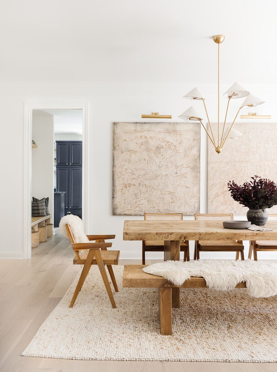 Modern Scandinavian dining area with light wood table, sculptural pendant lights, and neutral palette