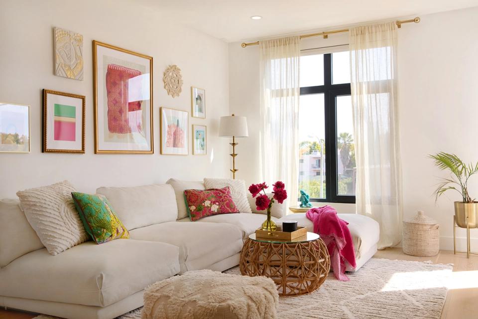 Airy, gallery-wall living space mixing boho charm with contemporary design via colorful art and natural woven elements.