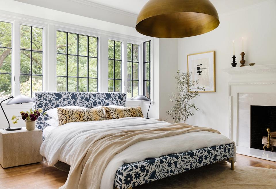 Modern staircase in sage green with gold-framed artwork, white walls, and emerald green bench below.