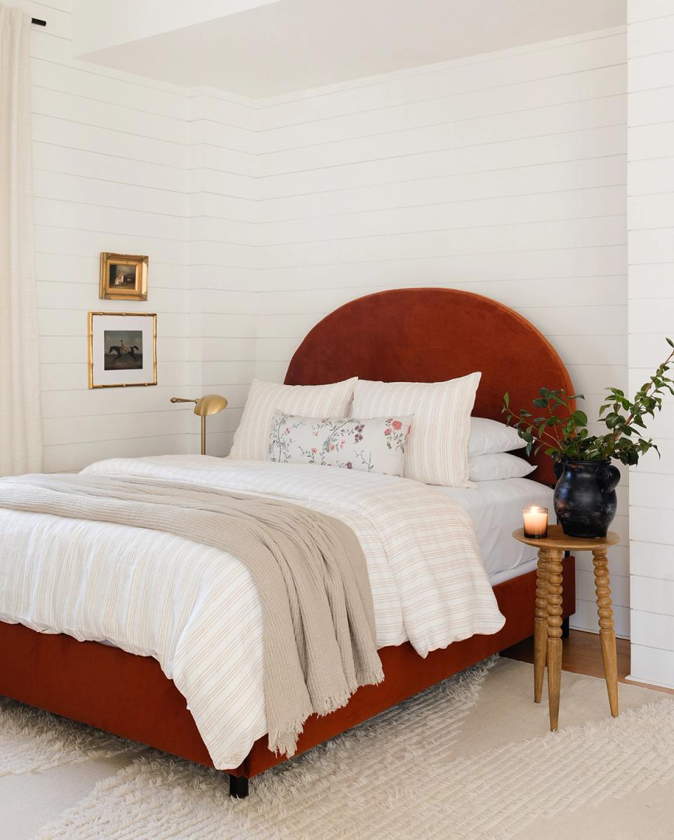 Eclectic bedroom with terracotta curved headboard, white shiplap, and vintage botanical touches