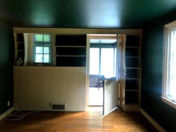 Before: Original dark interior with dated built-in shelving and wood cabinetry