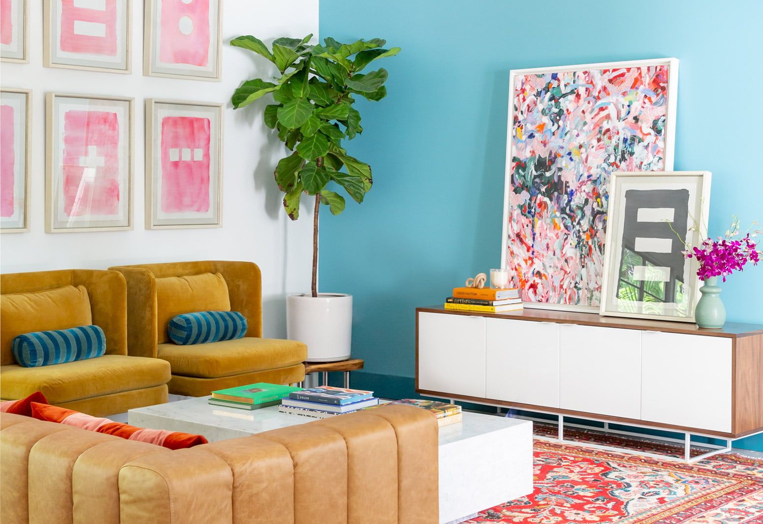 Bright maximalist living room with turquoise walls, mustard velvet sofa, playful patterned artwork, and lush hanging greenery creating a bold, eclectic vibe.