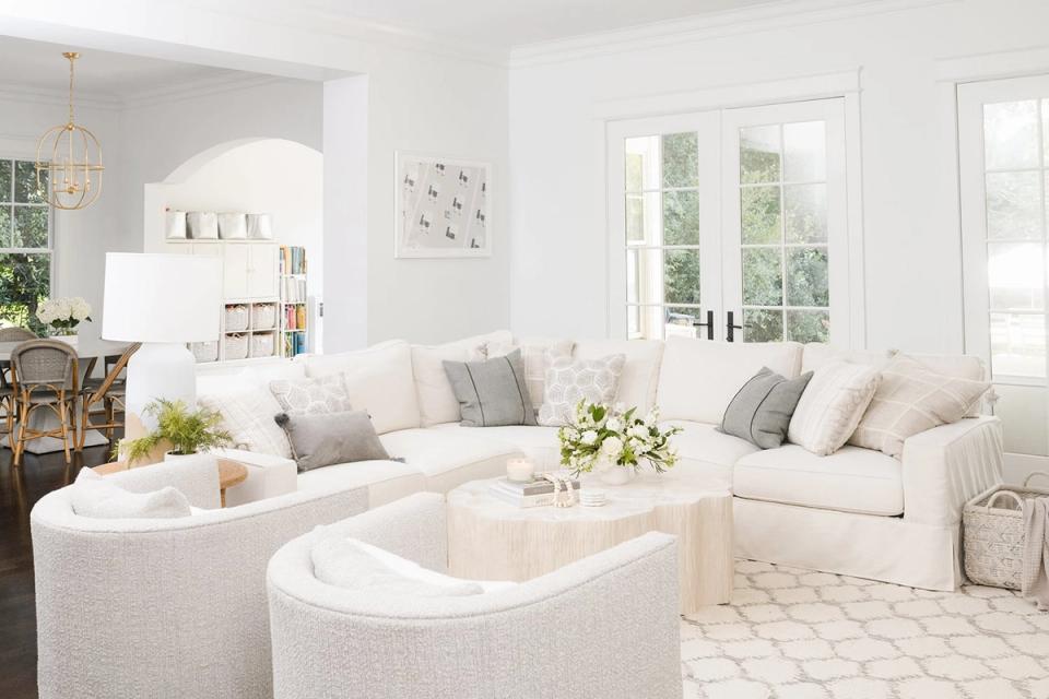 Serene coastal living room in soft whites and creams with curved seating and minimalist styling