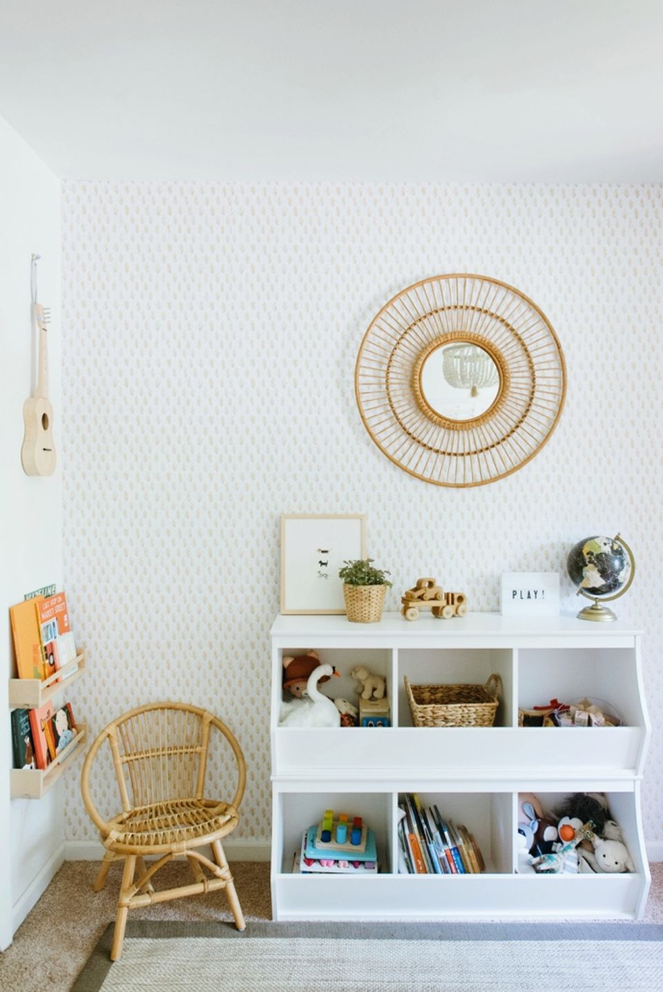 Scandinavian kids' room with woven accents, white open shelving, and soft geometric wallpaper