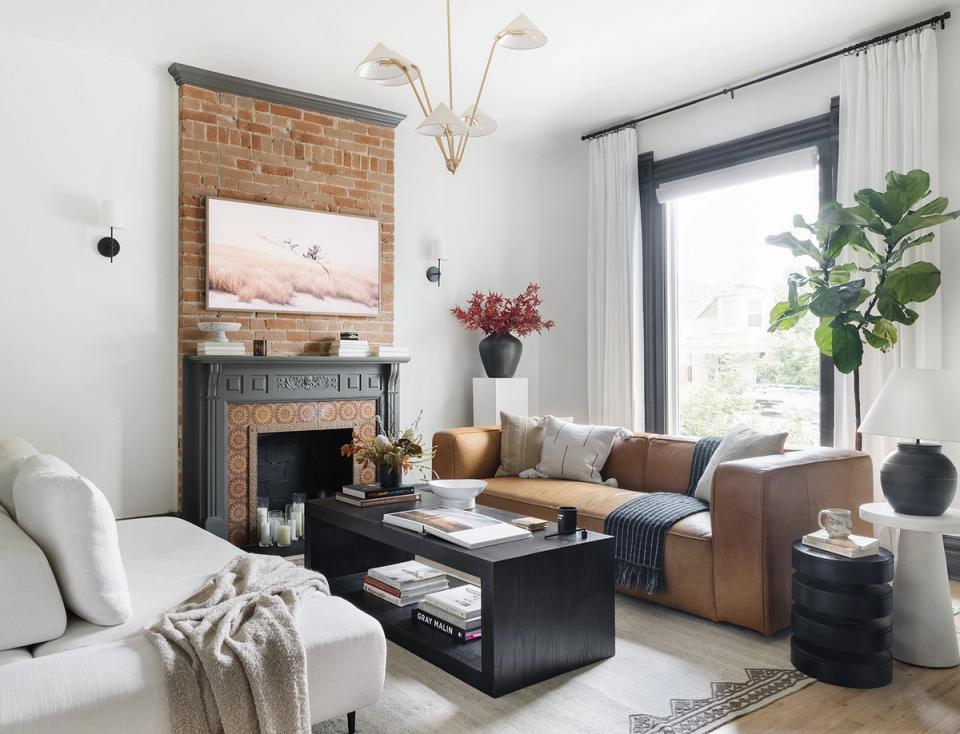 Contemporary living room with caramel leather sofa, exposed brick, and fireplace focal point