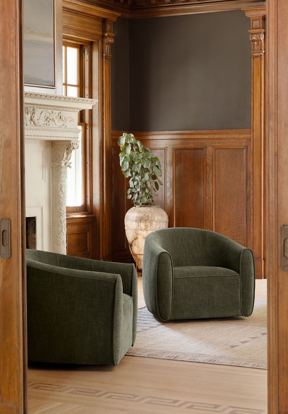 Elegant transitional room with charcoal upper walls, rich wood paneling, sage chairs