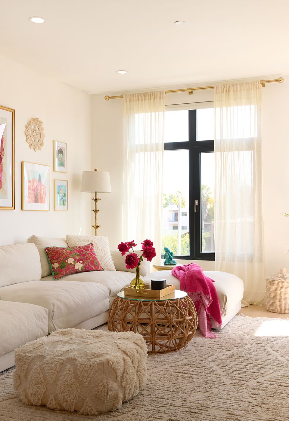 Warm beige living room with jewel-tone accents, natural light, and layered textures creating an inviting, sophisticated aesthetic