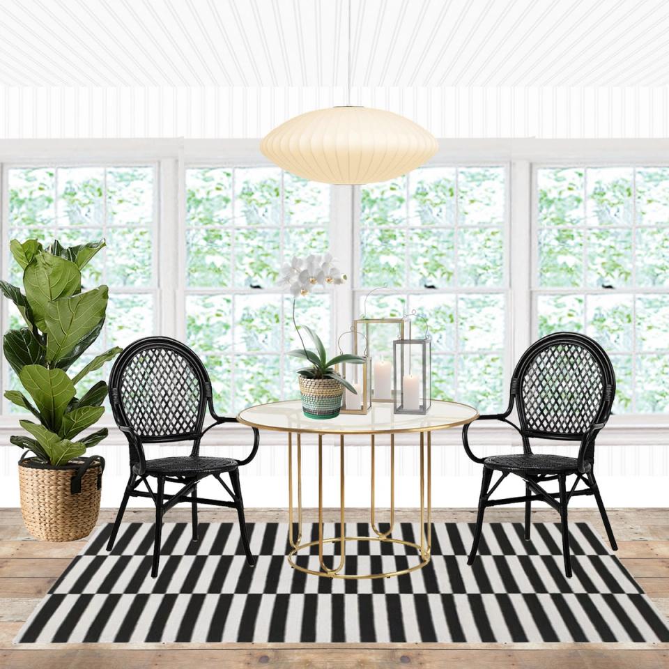 Scandinavian dining nook with black rattan chairs, geometric striped rug, and pendant light overlooking garden