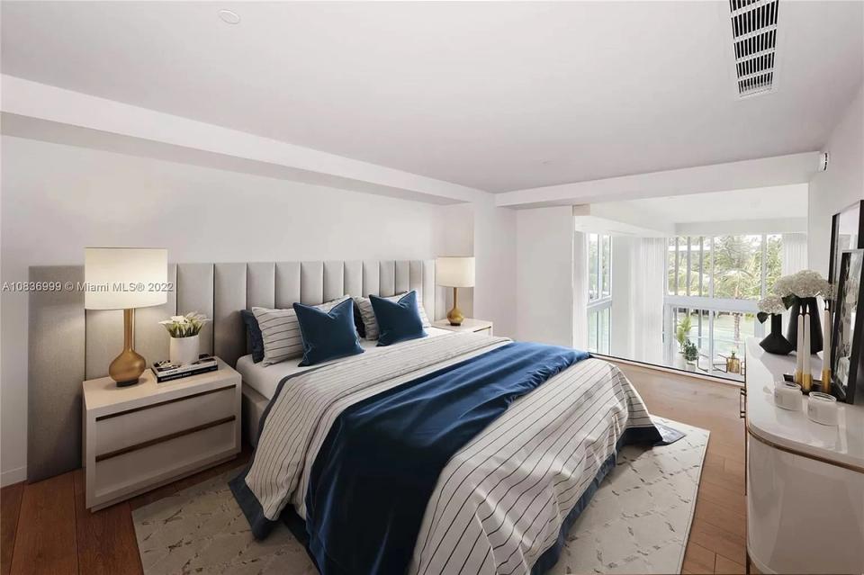 Contemporary bedroom with navy blue accents, grey upholstered headboard, and layered neutral palette