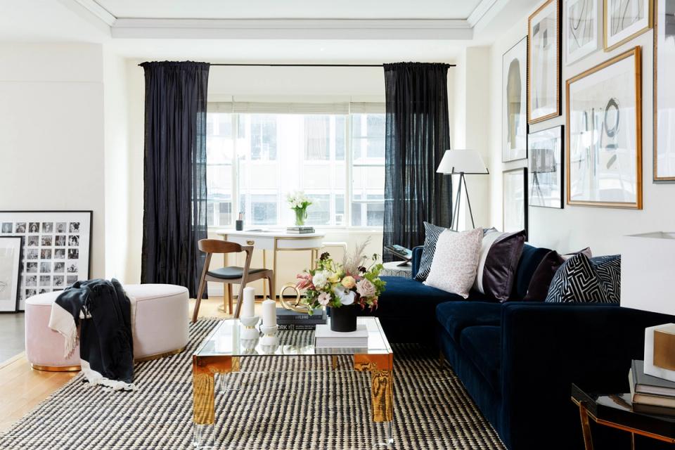 Modern eclectic living room with charcoal drapes, navy sofa, and striped area rug