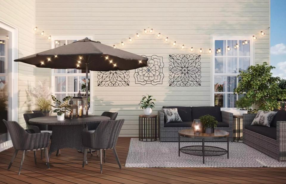 Modern patio with dark metal furniture, geometric wall art, ambient lighting, and minimalist coastal design aesthetic.