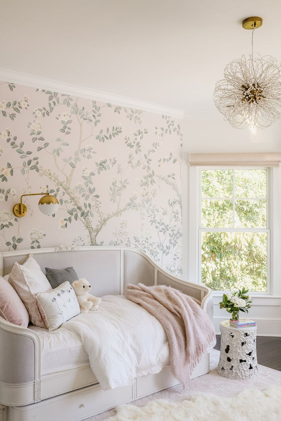 Serene botanical bedroom with soft florals, blush accents, brass chandelier, and cloud-like bedding