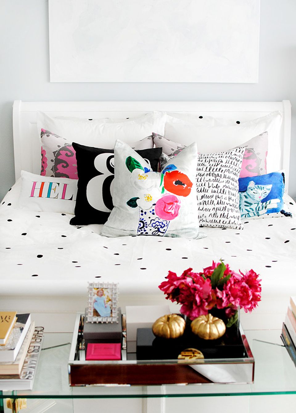 Eclectic dorm bed with colorful patterned pillows, polka-dot bedding, and vibrant accent styling