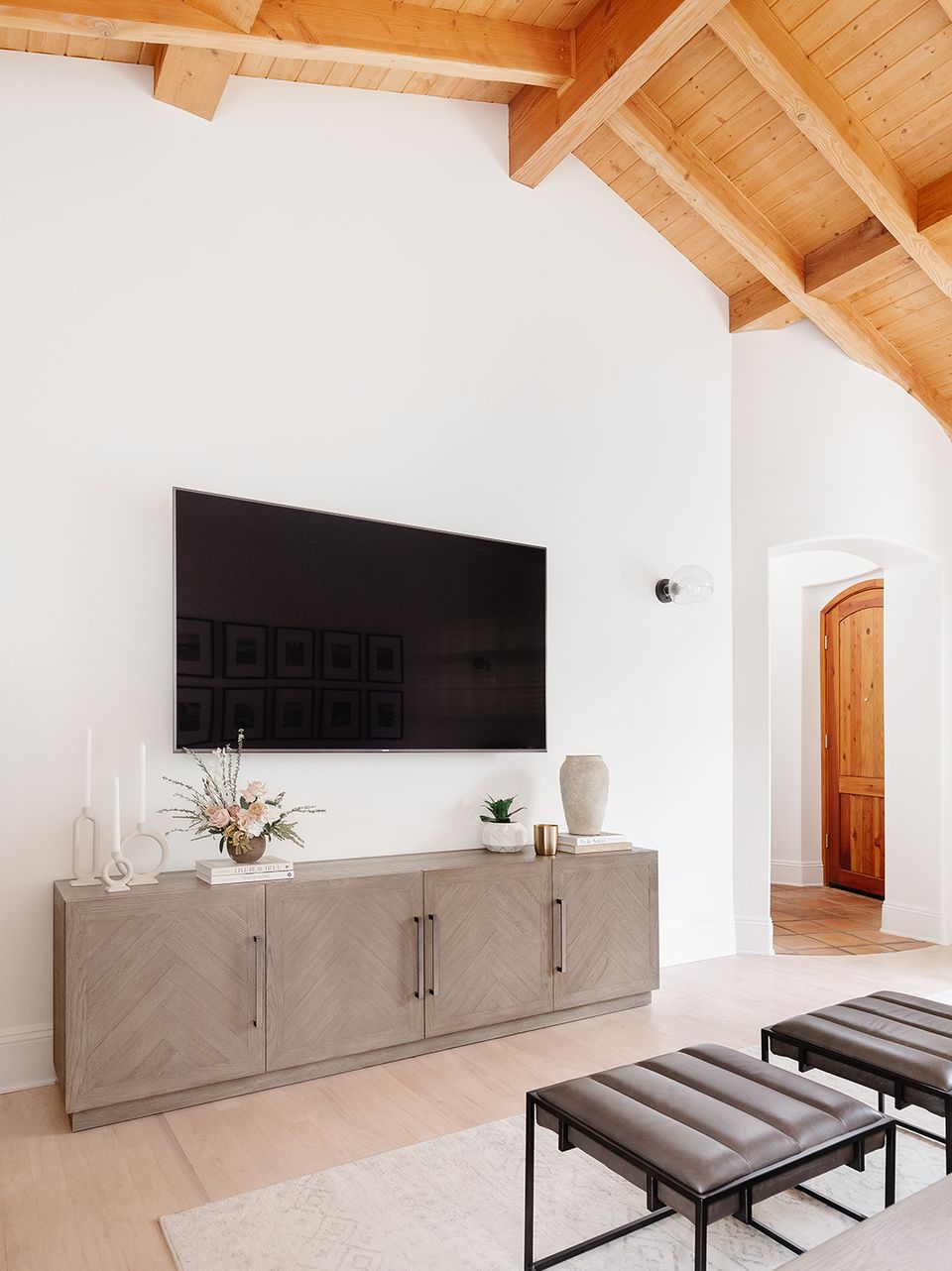 Scandinavian-inspired space with light wood ceiling beams and natural oak TV stand
