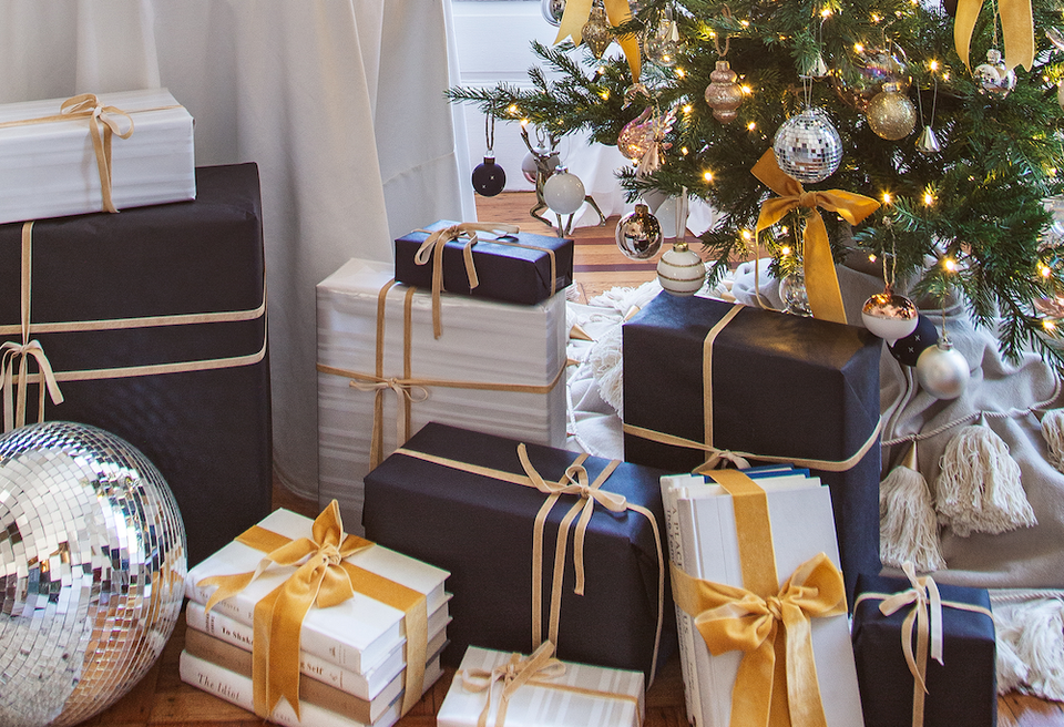 Luxe holiday scene with navy and gold wrapped gifts, glowing Christmas tree, and elegant minimalist décor