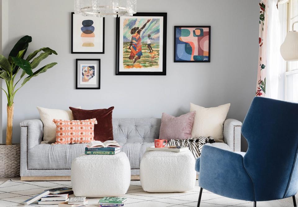 Modern seating area featuring blue chairs, curated gallery wall, and neutral tones with pops of coral accents