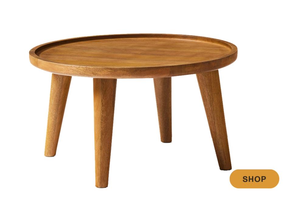 Mid-century round wooden coffee table with tapered legs and warm honey finish