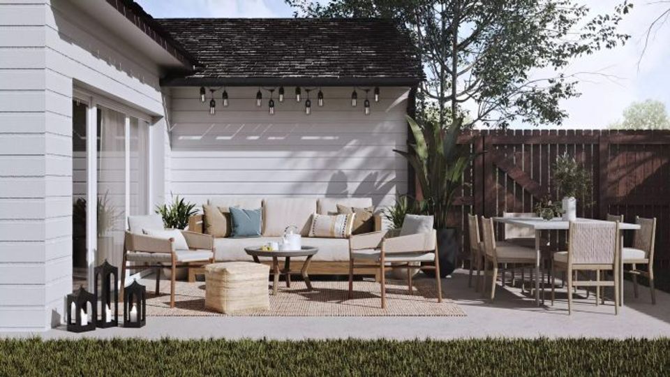 Farmhouse patio with white pergola, neutral upholstery, and soft lighting creating a welcoming, casual aesthetic.