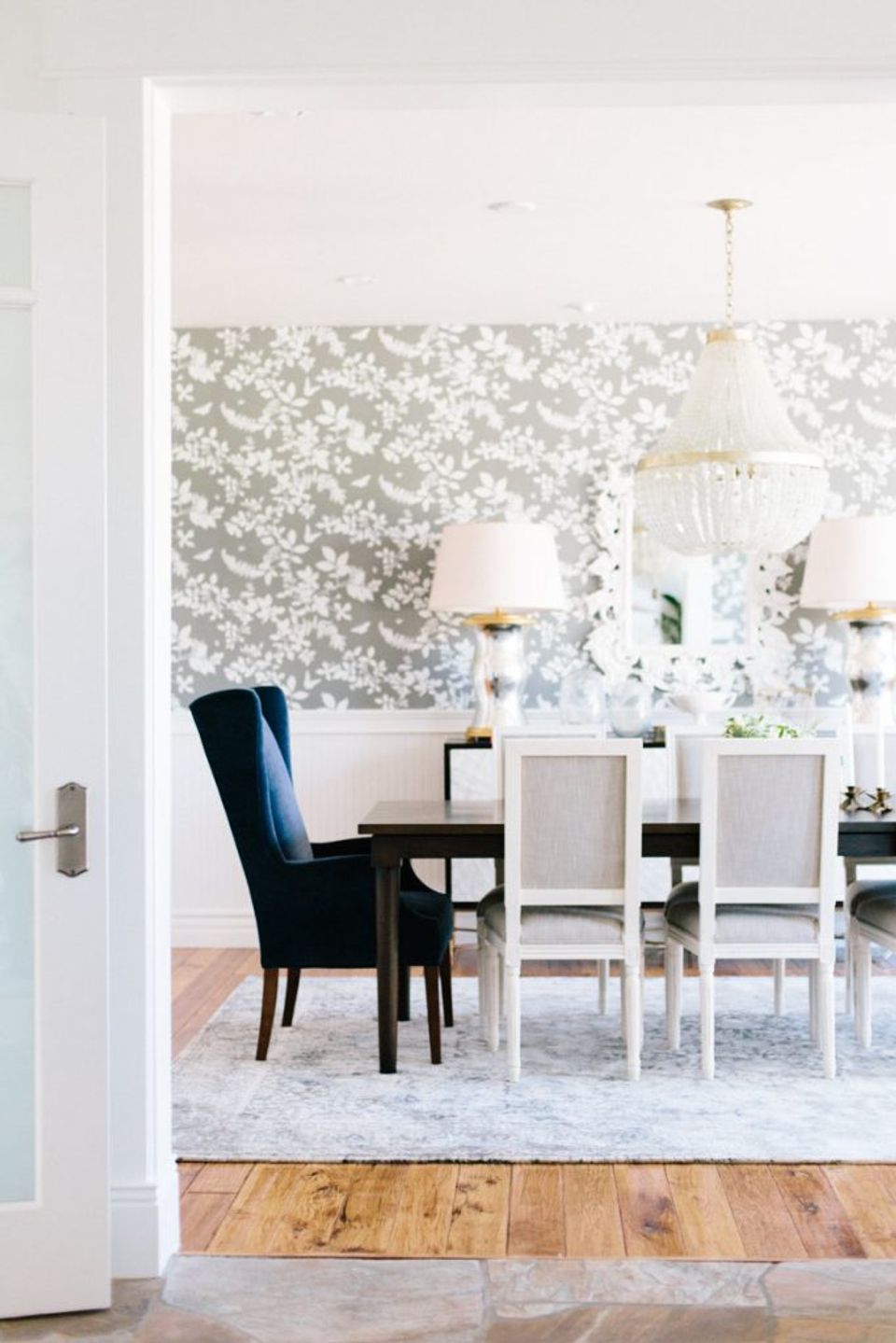 Elegant dining room with gray floral damask wallpaper, white shiplap, and classic furnishings in soft, sophisticated palette.