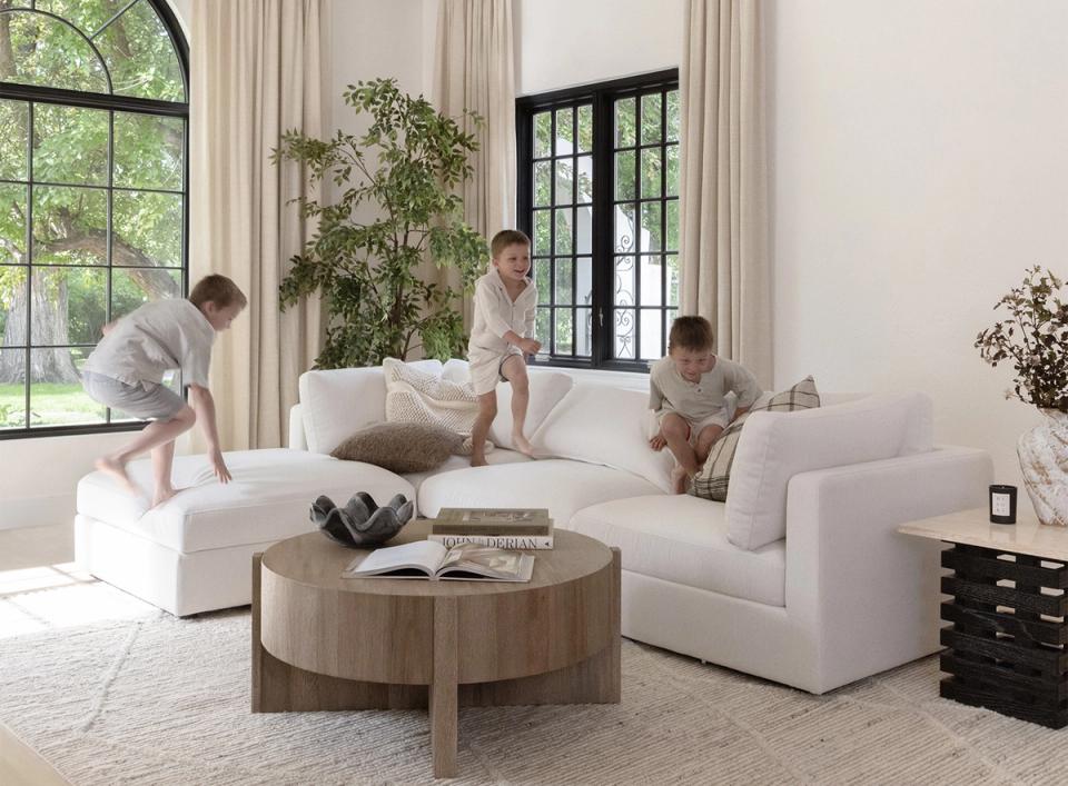 Bright Scandinavian family room with cream sectional, wooden coffee table, and natural light