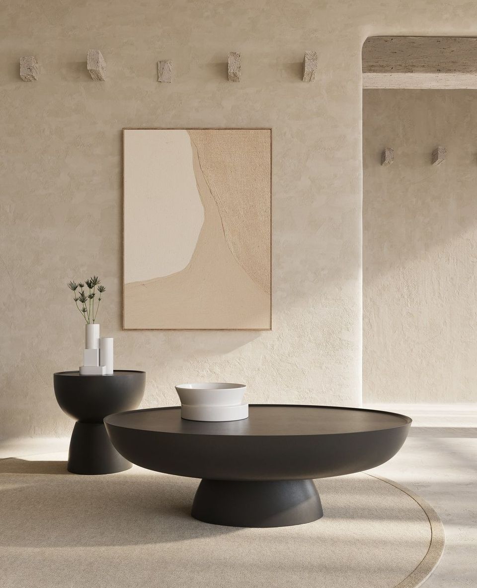 Contemporary Scandinavian living room with sculptural black bowl table, cream abstract art, neutral palette