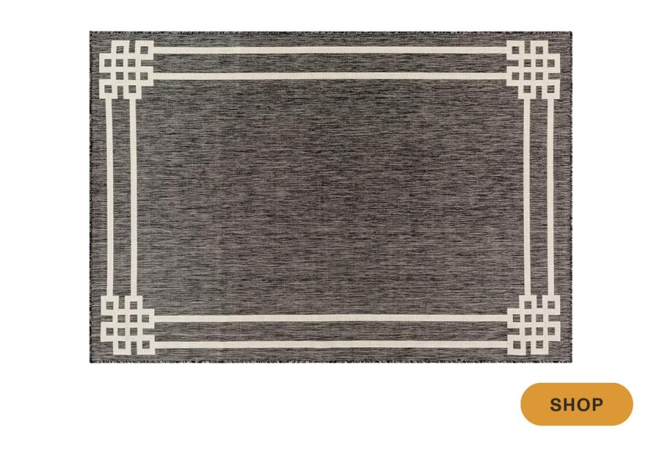 Contemporary outdoor rug with charcoal texture and geometric white corner details