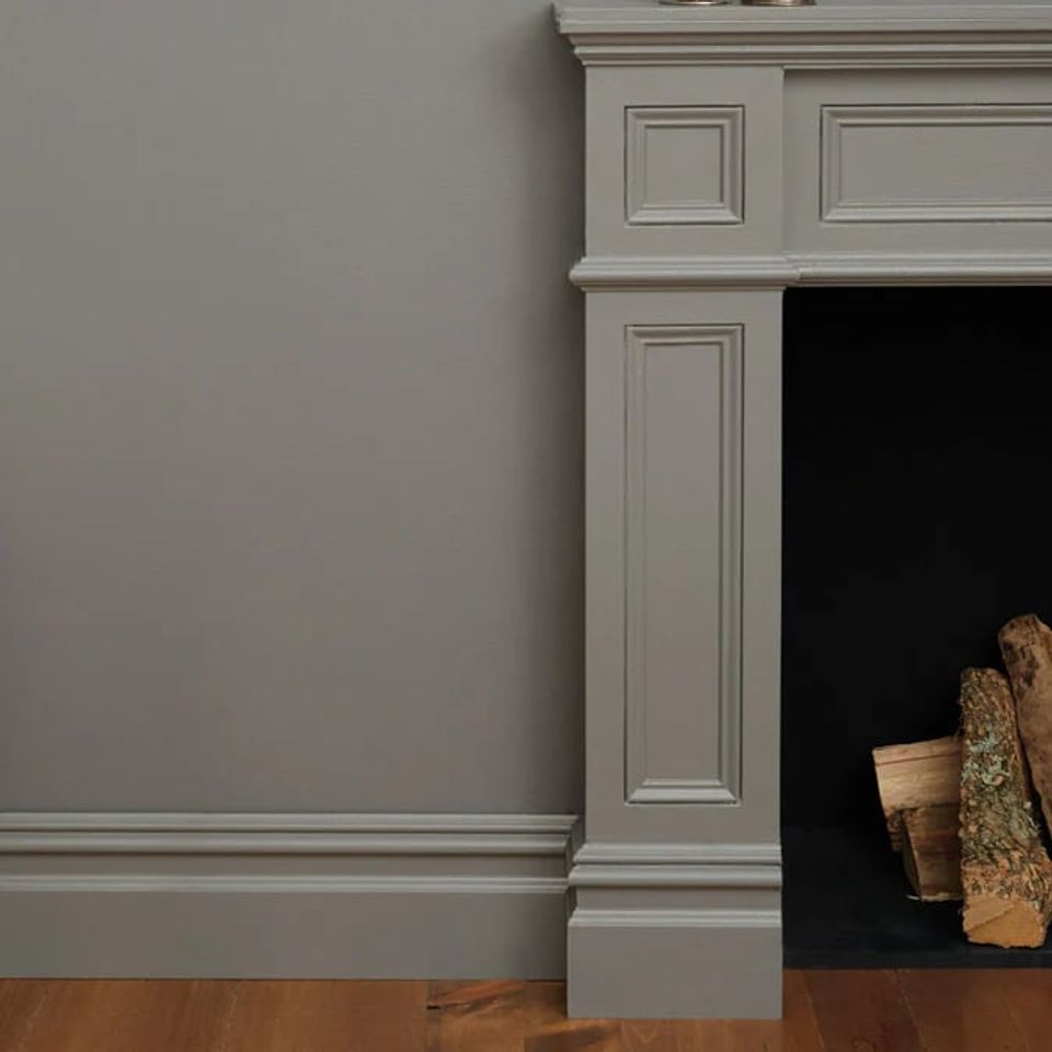 Contemporary fireplace surround with soft sage-gray walls and pale trim molding in understated modern style