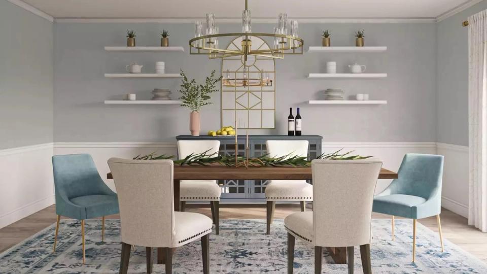 Serene coastal dining space with soft blue-gray walls, open shelving, and upholstered accent chairs