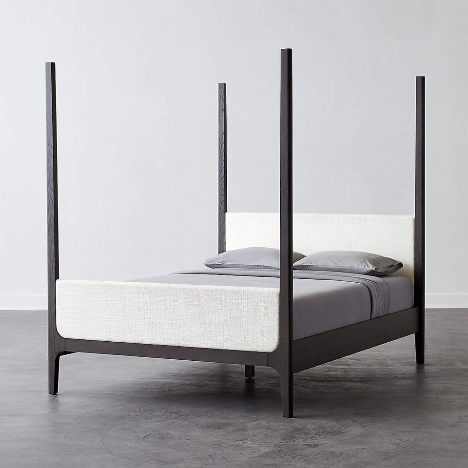 Modern industrial canopy bed with black metal posts and minimalist aesthetic