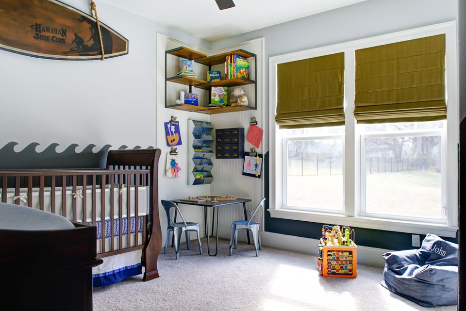 Bright surf shack nursery featuring sage green trim, wooden surfboard art, and organized toy storage